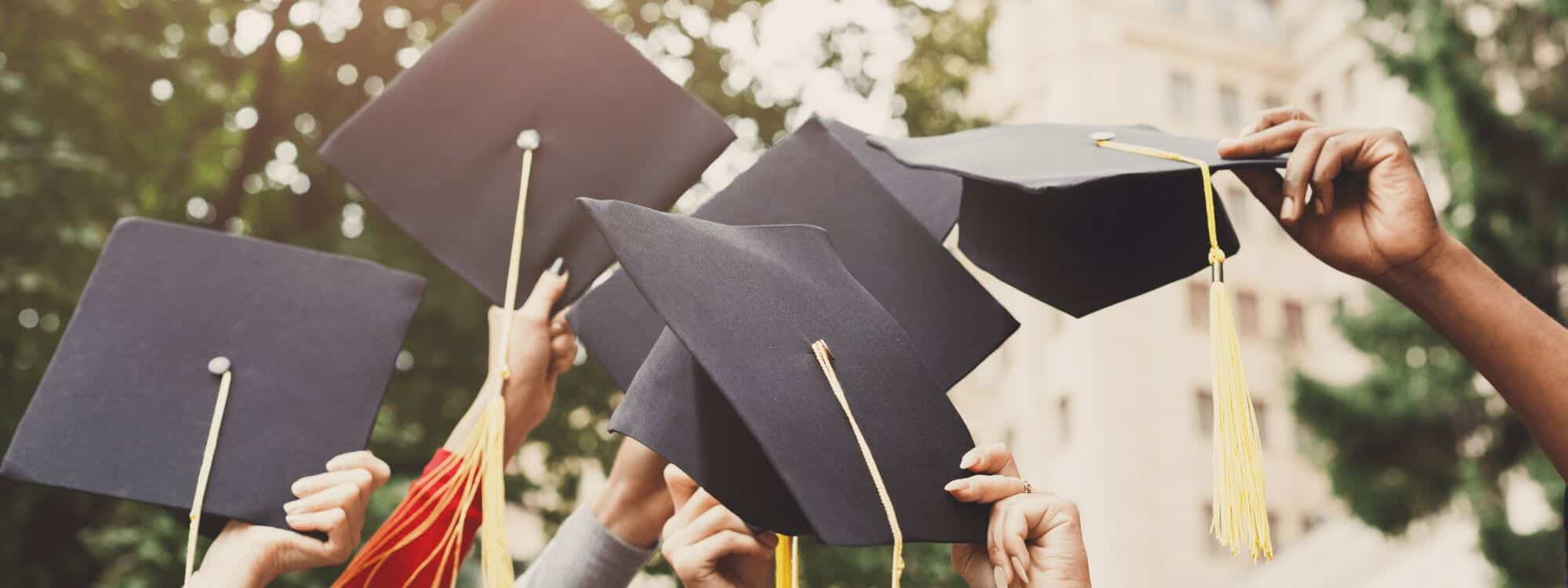 A group throw up their mortarboard hats at Graduation after contacting Southpac Aerospace to find out how they could complete their Diplomas sooner.