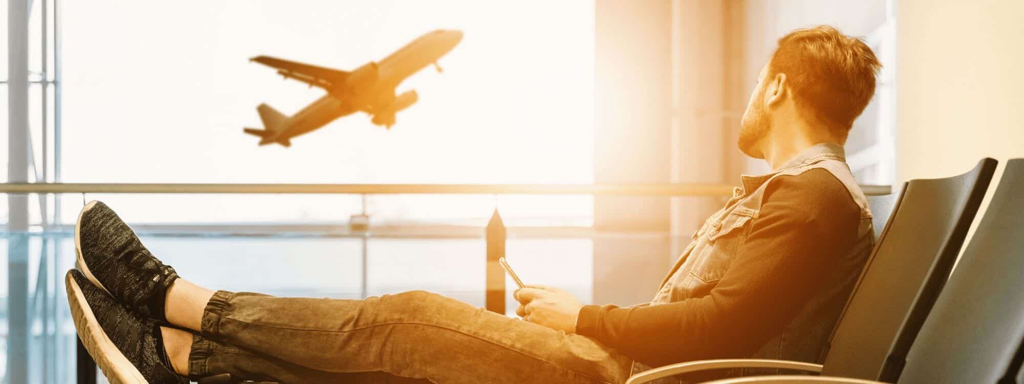 A man sitting in the airport watches as a plane takes off amid higher living costs, resulting in course price changes coming for Southpac Aerospace in 2020.