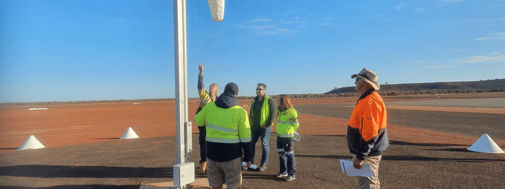 Participants of Southpac Aerodromes Works Safety Officer course inspect rural airport windsock.